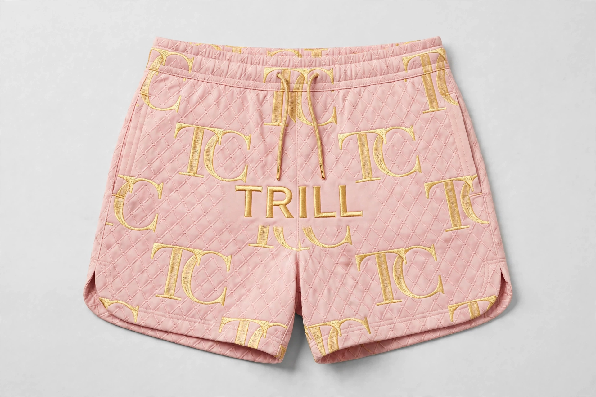 Pink quilted women’s shorts with gold TC monogram print and TRILL lettering across the front